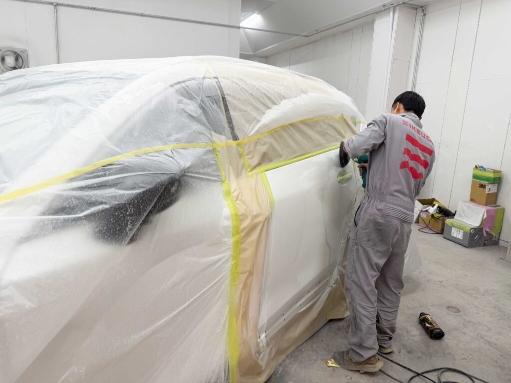 【板金塗装の裏側】なぜ下塗り後に「削る」のか?塗装の寿命とツヤを決める職人の研磨技術