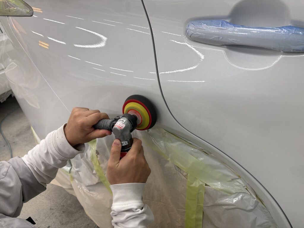 ポリッシャーで塗装面を磨いて仕上げる作業