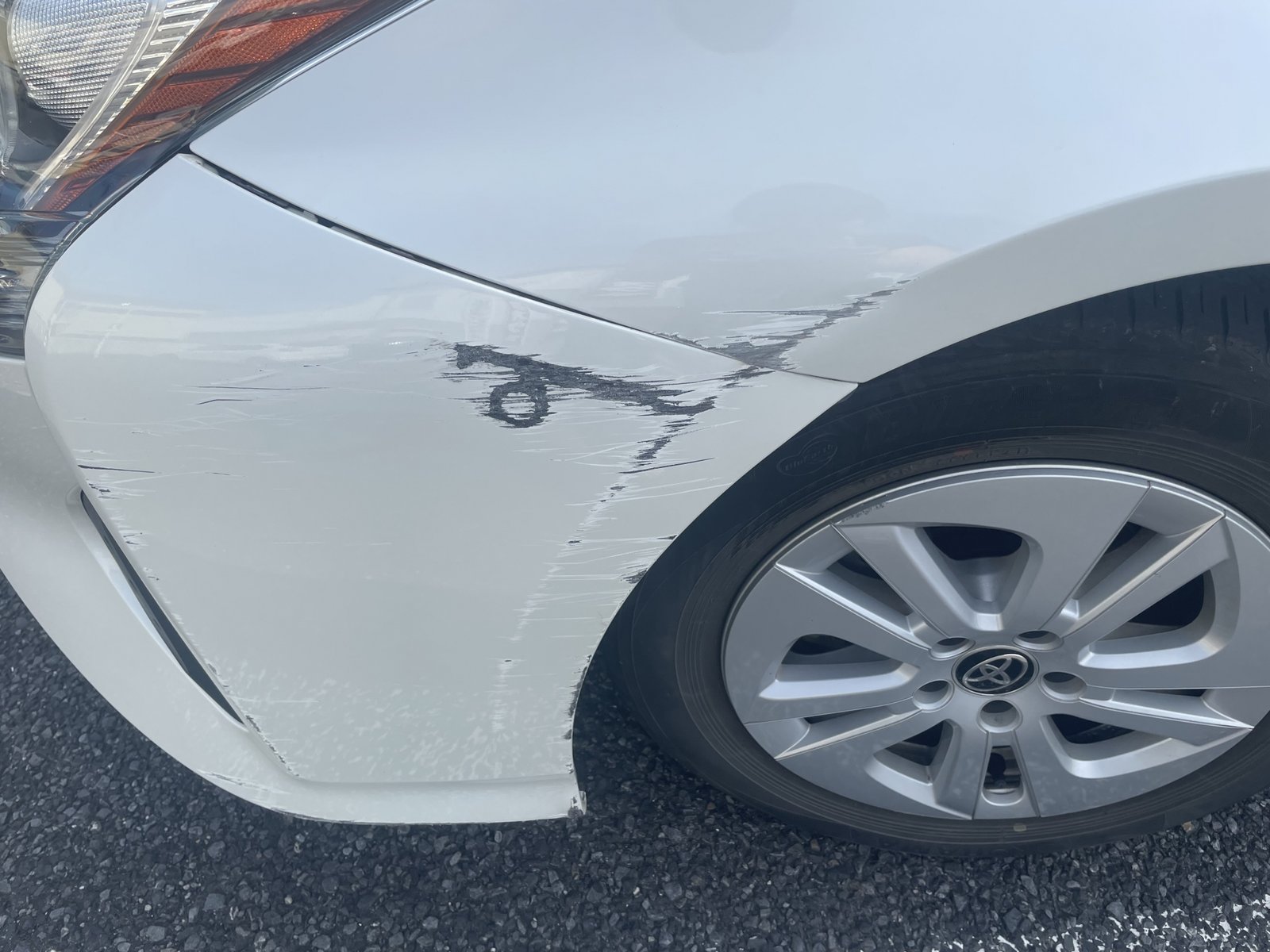 フロントフェンダーの塗膜が剥がれた白い車
